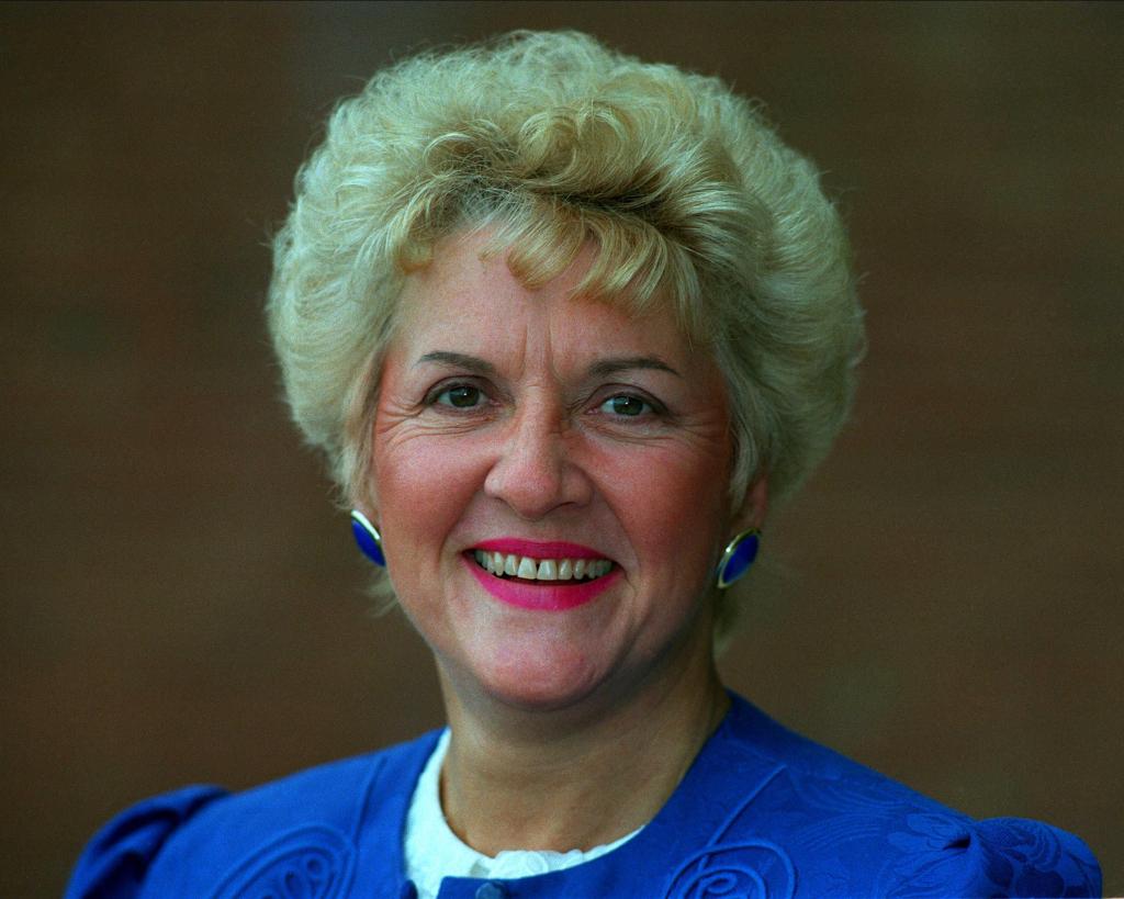 Teresa Gorman, head and shoulders photo with blonde hair and royal blue earring and top